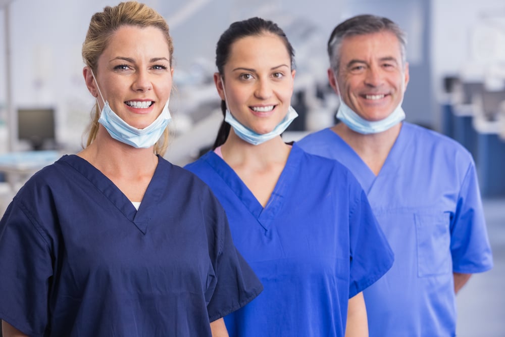 Portrait of smiling co-workers standing in a line in dental clinic-3